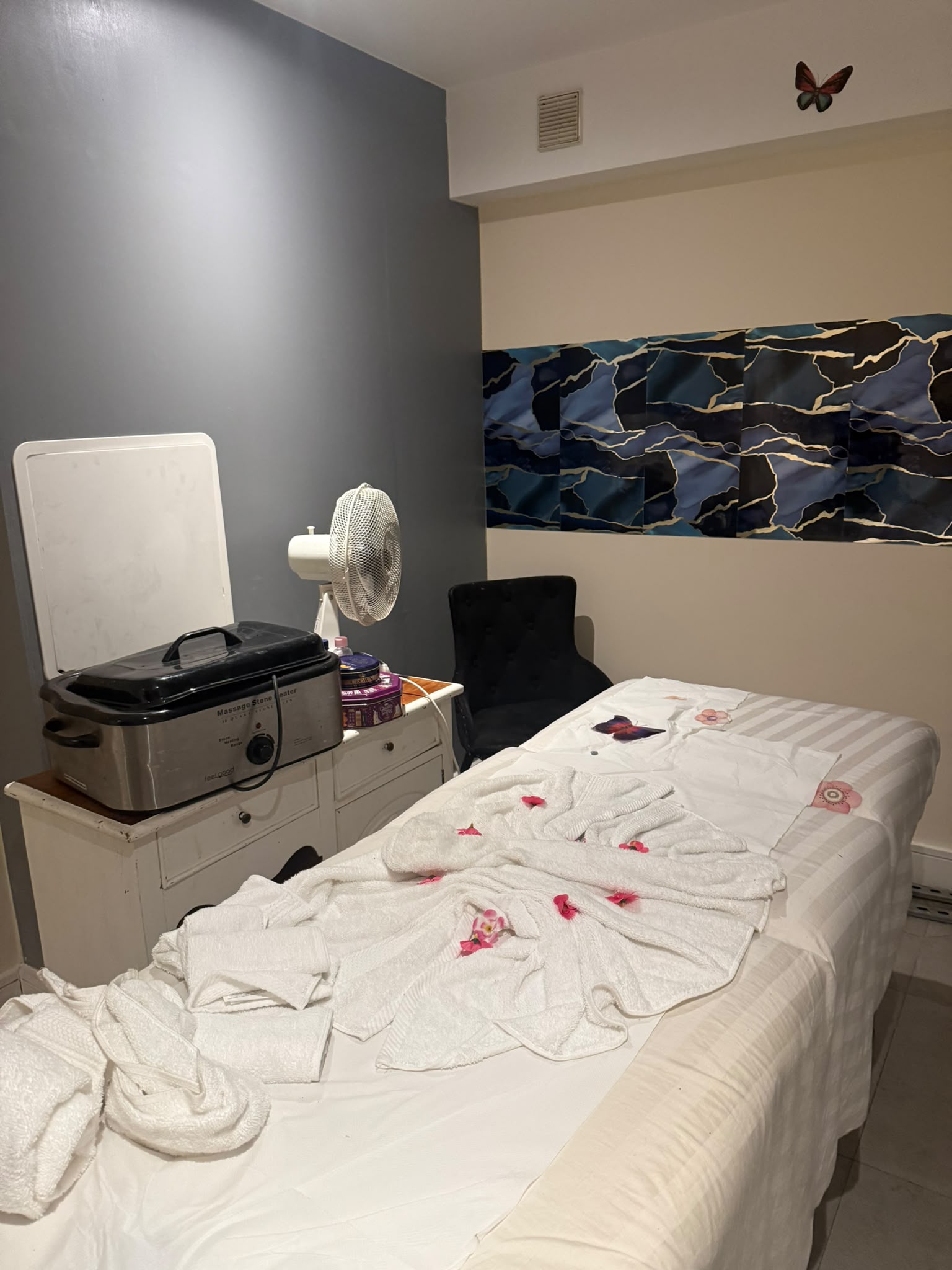 Letitia Antoinette spa treatment room with dressed therapy bed and stone heater